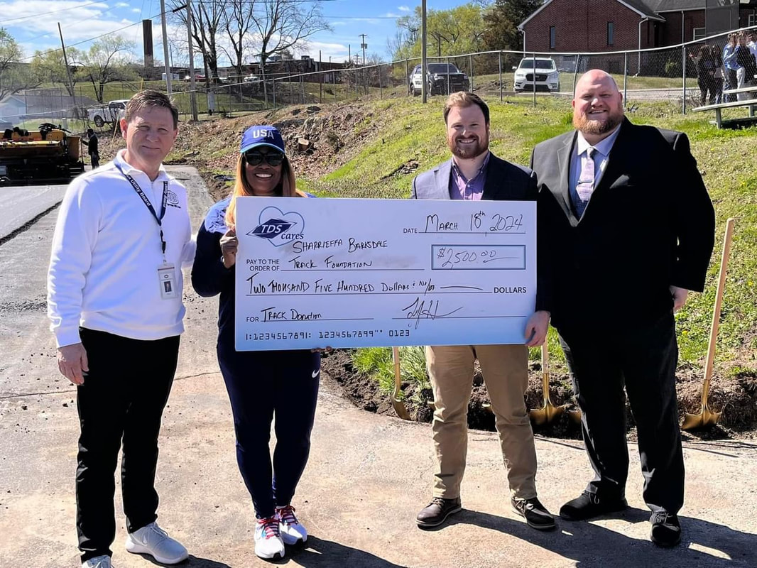A $2,500 TDS Cares donation check presented at the track construction site