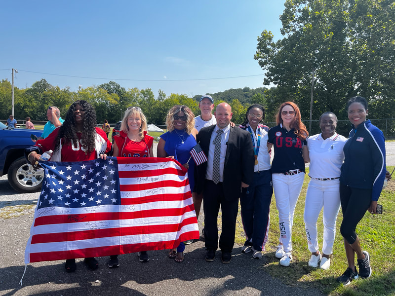 A group of supporters holding a large American flag covered in signatures